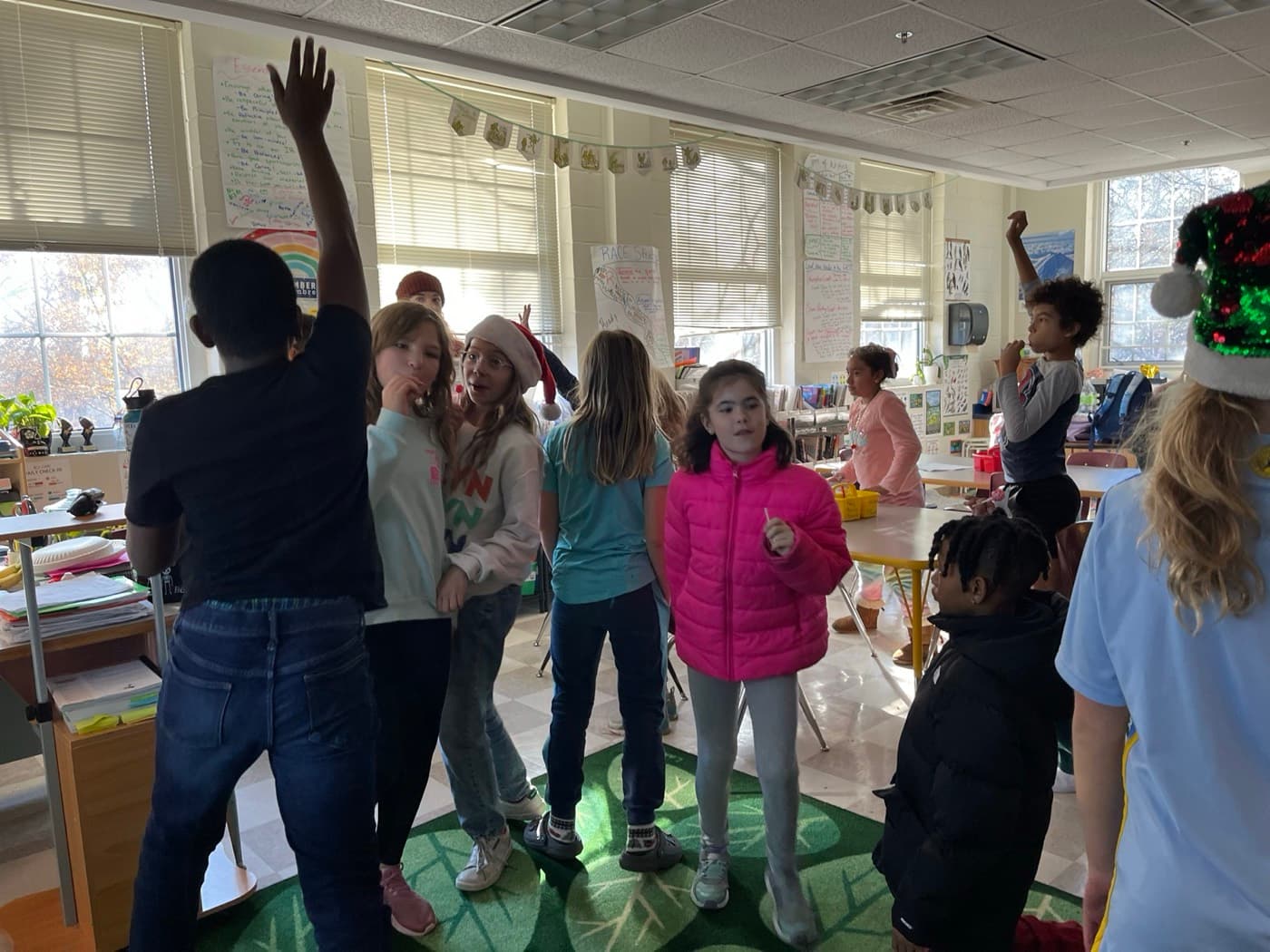 Elementary students playing an environmental game on a giant leaf rug